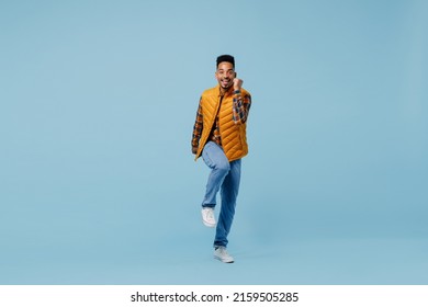 Full size body length jubilant young black man 20s years old wears yellow waistcoat shirt doing winner gesture celebrate clenching fists isolated on plain pastel light blue background studio portrait