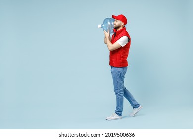 Full Size Body Length Side View Delivery Guy Man In Red Cap White T-shirt Vest Uniform Workwear Work As Dealer Courier Hold Water Bottle Isolated On Pastel Blue Color Background Studio Service Concept