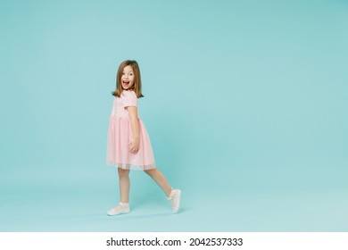 Full Size Body Length Side View Little Fun Cute Kid Girl 5-6 Years Old Wears Pink Dress Dancing Isolated On Pastel Blue Color Background Child Studio Portrait. Mother's Day Love Family People Concept