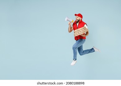 Full Size Body Length Side View Delivery Guy Employee Man In Red Cap White T-shirt Vest Uniform Work As Dealer Courier Jump Run Go Walk Isolated On Pastel Blue Color Background Studio. Service Concept