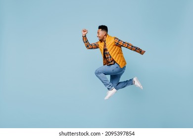 Full Size Body Length Side Profile View Jubilant Excited Young Black Man 20s Years Old Wears Yellow Waistcoat Shirt Looking Aside Jump Isolated On Plain Pastel Light Blue Background Studio Portrait