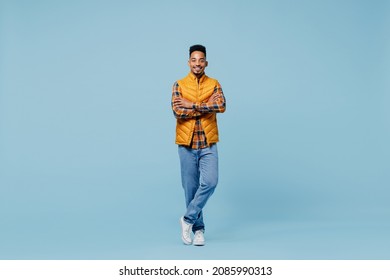 Full Size Body Length Smiling Fascinating Young Black Man 20s Years Old Wears Yellow Waistcoat Shirt Looking Camera Hold Hands Crossed Isolated On Plain Pastel Light Blue Background Studio Portrait