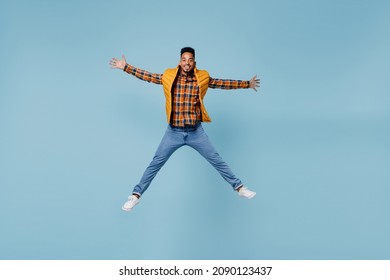 Full Size Body Length Surprised Shocked Excited Fun Young Black Man 20s Years Old Wears Yellow Waistcoat Shirt Jump With Spreading Hands Isolated On Plain Pastel Light Blue Background Studio Portrait