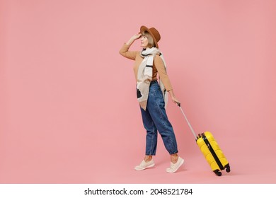 Full Size Body Length Traveler Tourist Mature Elderly Senior Lady Woman 55 Years Old Wear Brown Shirt Hat Scarf Hold Suitcase Bag Go Move Isolated On Plain Pastel Light Pink Background Studio Portrait