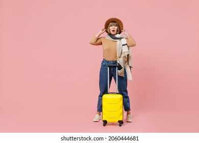 Full Size Body Length Traveler Tourist Shocked Mature Elderly Senior Woman 55 Years Old Wears Casual Clothes Hat Scarf Hold Suitcase Bag Isolated On Plain Pastel Light Pink Background Studio Portrait