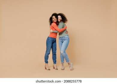 Full Size Body Length Two Friendly Fun Young Curly Black Women Friends 20s Wear Casual Shirts Clothes Meeting Greeting Hugging Looking Camera Isolated On Plain Pastel Beige Background Studio Portrait