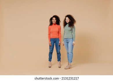 Full Size Body Length Two Fun Charming Young Curly Black Women Friends 20s Wear Casual Shirts Clothes Meeting Greeting Posing Looking Camera Isolated On Plain Pastel Beige Background Studio Portrait