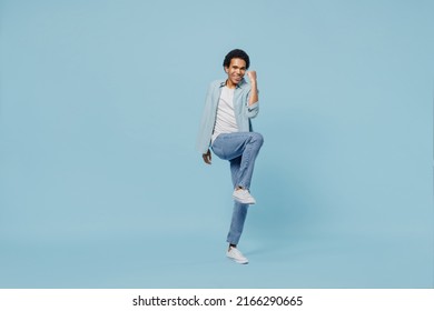 Full Size Body Length Vivid Young Black Curly Man 20s Years Old Wears White Shirt Doing Winner Gesture Celebrate Clenching Fists Say Yes Isolated On Plain Pastel Light Blue Background Studio Portrait