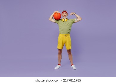 Full Size Body Length Vivid Elderly Gray-haired Bearded Man 60s Years Old In Headband Khaki T-shirt Hold Basketball Show Biceps Muscles Isolated On Plain Pastel Light Purple Background Studio Portrait