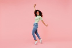 Full Size Body Length Young Curly Latin Woman 20s Wears Casual Clothes Sunglasses Stand On Toes Dance Lean Back Have Fun Spreading Hands Isolated On Plain Pastel Light Pink Background Studio Portrait
