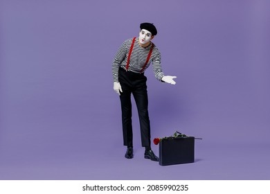 Full Size Body Length Young Mime Man With White Face Mask Wears Striped Shirt Beret Show Point Hand Down On Suitcase Bag Rose Flower Isolated On Plain Pastel Light Violet Background Studio Portrait