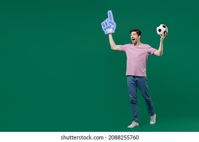 Full Size Body Length Young Fun Man Fan Wear Basic Pink T-shirt Cheer Up Support Football Sport Team Hold In Hand Soccer Ball Watch Tv Live Stream Scream Isolated On Dark Green Color Background Studio