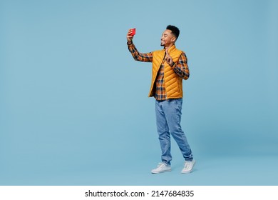 Full Size Body Length Young Black Man 20s Wears Yellow Waistcoat Shirt Do Selfie Shot On Mobile Cell Phone Post Photo On Social Network Isolated On Plain Pastel Light Blue Background Studio Portrait