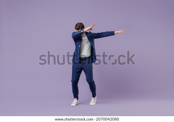 Full size body length young successful employee
business man lawyer 20s wear formal blue suit white t-shirt do dab
hip hop dance hands move gesture isolated on pastel purple
background studio portrait