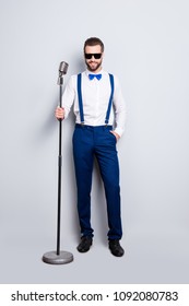 Full Size Full Body Portrait Of Cheerful Elegant Singer With Bristle In Blue Outfit White Shirt Holding Hand In Pocket, Having Mic, Isolated Over Grey Background