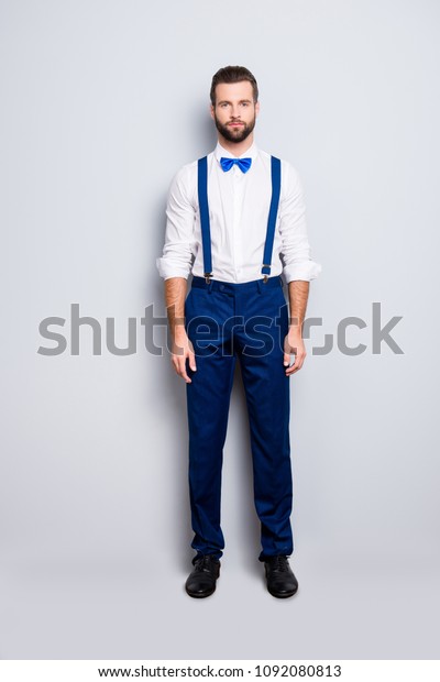 Full size full body portrait of handsome\
attractive singer in blue ourfit, wearing bowtie, white shirt,\
suspenders, isolated over grey\
background