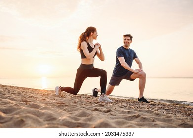 Full size couple young two friend strong sporty sportswoman sportsman woman man in sport clothes warm up training do lunges do exercise on sand sea ocean beach outdoor on seaside in summer day morning - Powered by Shutterstock