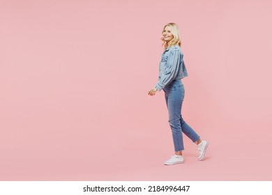 Full size elderly smiling cheerful fun happy woman 50s wearing denim jacket walking going look aside isolated on plain pastel light pink background studio portrait. People lifestyle fashion concept - Powered by Shutterstock