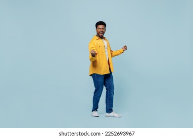 Full size excited young man of African American ethnicity 20s wear yellow shirt doing winner gesture celebrate clenching fists say yes isolated on plain pastel light blue background studio portrait. - Shutterstock ID 2252693967