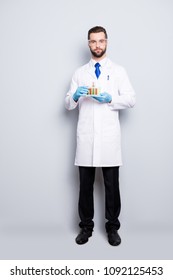 Full Size Fullbody Portrait Of Attractive Stylish  Scientist In White Lab Coat, Black Pants, Blue Tie Holding Test Tubes With Multi-colored Liquid, Looking At Camera, Isolated On Grey Background