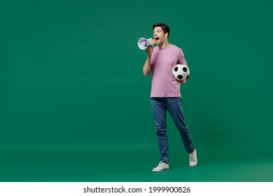 Full Size Length Young Crazy Fun Man Fan Wears Basic Pink T-shirt Cheer Up Football Sport Team Hold Soccer Ball Watch Tv Live Stream Scream In Megaphone Isolated On Dark Green Color Background Studio