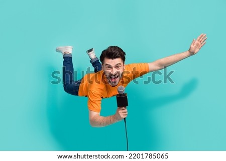 Full size photo of active guy reporter hold mic tell news on tv video show isolated on cyan color background