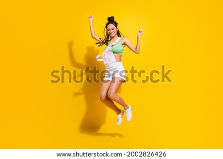 Full size photo of afro american positive young woman jump up winner isolated on yellow color background