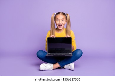 Full size photo of amazed excited child show laptop show touch screen scream wow omg sit crossed folded legs wear casual style outfit isolated over violet color background