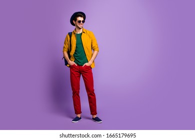 Full Size Photo Of Attractive Gorgeous Guy Have Spring Walk Holidays Put Hands In Pockets Wear Blue Bag Velvet Hat Sunglass Retro Outfit Isolated Over Purple Color Background