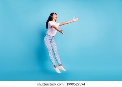 Full size photo of attractive young charming woman open hands empty space jump isolated on blue color background