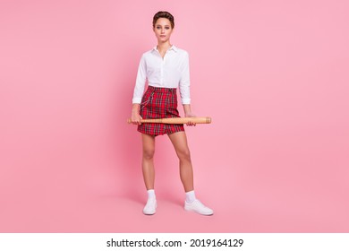 Full size photo of attractive young serious cool woman hold hands baseball bat isolated on pink color background - Powered by Shutterstock