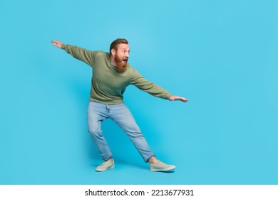 Full size photo of attractive young guy surfing invisible wave have fun dancing fooling wear khaki look isolated on cyan color background - Powered by Shutterstock