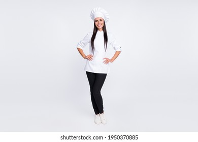 Foto de tamaño completo de una persona encantadora y alegre de pie poniéndose manos sobre la gorra de la cintura aislada en fondo de color blanco