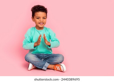 Full size photo of charming small boy sit floor clap hands applause dressed stylish cyan outfit isolated on pink color background - Powered by Shutterstock