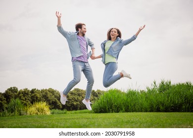 Full size photo of cheerful excited crazy funky funny married couple jumping fooling around enjoying summer vacation
