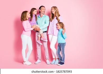 Full size photo of cheerful idyllic family dad hold carry small younger daughter mommy laughing enjoy fun time hold hand son isolated over pastel color background - Shutterstock ID 1825787093