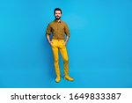 Full size photo of content candid guy enjoy spring free time holiday put hands pocket wear stylish colorful outfit footwear isolated over vibrant color background