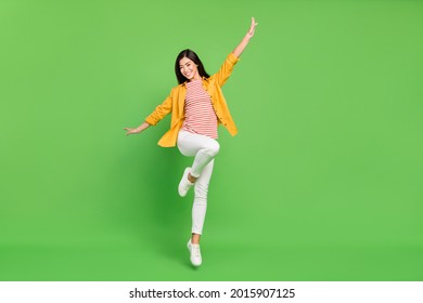 Full size photo of cool brunette millennial lady jump wear shirt trousers isolated on green color background