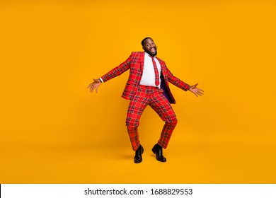 Full size photo of crazy dark skin guy dance youth moves bachelor men stag party enjoy popular song wear plaid red costume blazer pants shoes isolated yellow color background