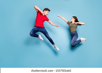Full size photo of crazy man two people woman man spouses disagree jump fight kick boxing wear green red t-shirt denim jeans sneakers isolated over blue color background
