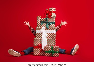 Full size photo of cute little boy hide behind present pile celebrate new year wear knitted outfit isolated on red color background - Powered by Shutterstock