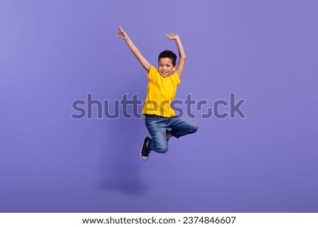 Full size photo of cute young schoolboy jumping have fun dancing dressed yellow clothes isolated on violet color background
