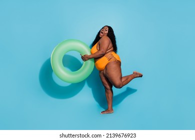 Full size photo of excited chubby lady proud conscious her body hold toy water circle isolated over blue color background.