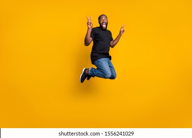 Full size photo of funky crazy afro american brunette hair guy jump fun spring weekends holidays make v-signs wear stylish outfit sneakers isolated over shine color background