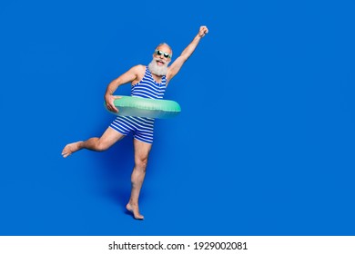 Full size photo of funky funny positive smiling mature superman with buoy on waist isolated on blue color background