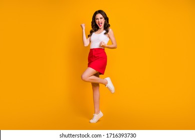 Full size photo of funny lady open mouth raise fists crazy achievement screaming loud wear casual white tank-top red mini skirt shoes isolated yellow bright color background