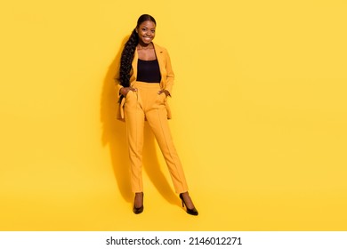 Full Size Photo Of Good Millennial Lady Stand Wear Suit Stilettos Isolated On Yellow Color Background