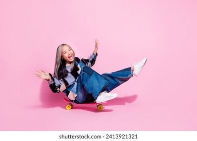 Full size photo of good mood positive girl dressed jeans pullover riding skateboard to empty space isolated on pink color background - Powered by Shutterstock