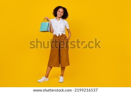Full size photo of gorgeous positive lady arm hold small boutique bag isolated on yellow color background