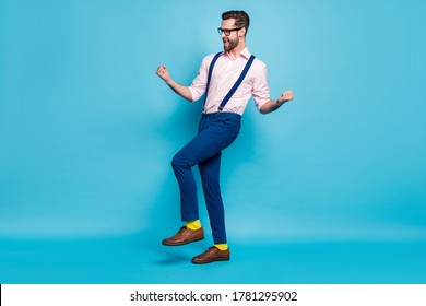 Full Size Photo Of Handsome Business Man Successful Young Promoted Worker Raise Fists Excited Win Corporate Competition Wear Specs Shirt Suspenders Pants Shoes Isolated Blue Color Background
